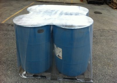 Four, blue, 55 Gallon Drums stretch wrapped to a pallet using the TAB Wrapper Tornado orbital wrapper